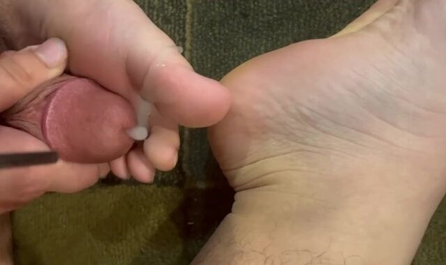 T lady plays with her feet and shoots a load on her toes